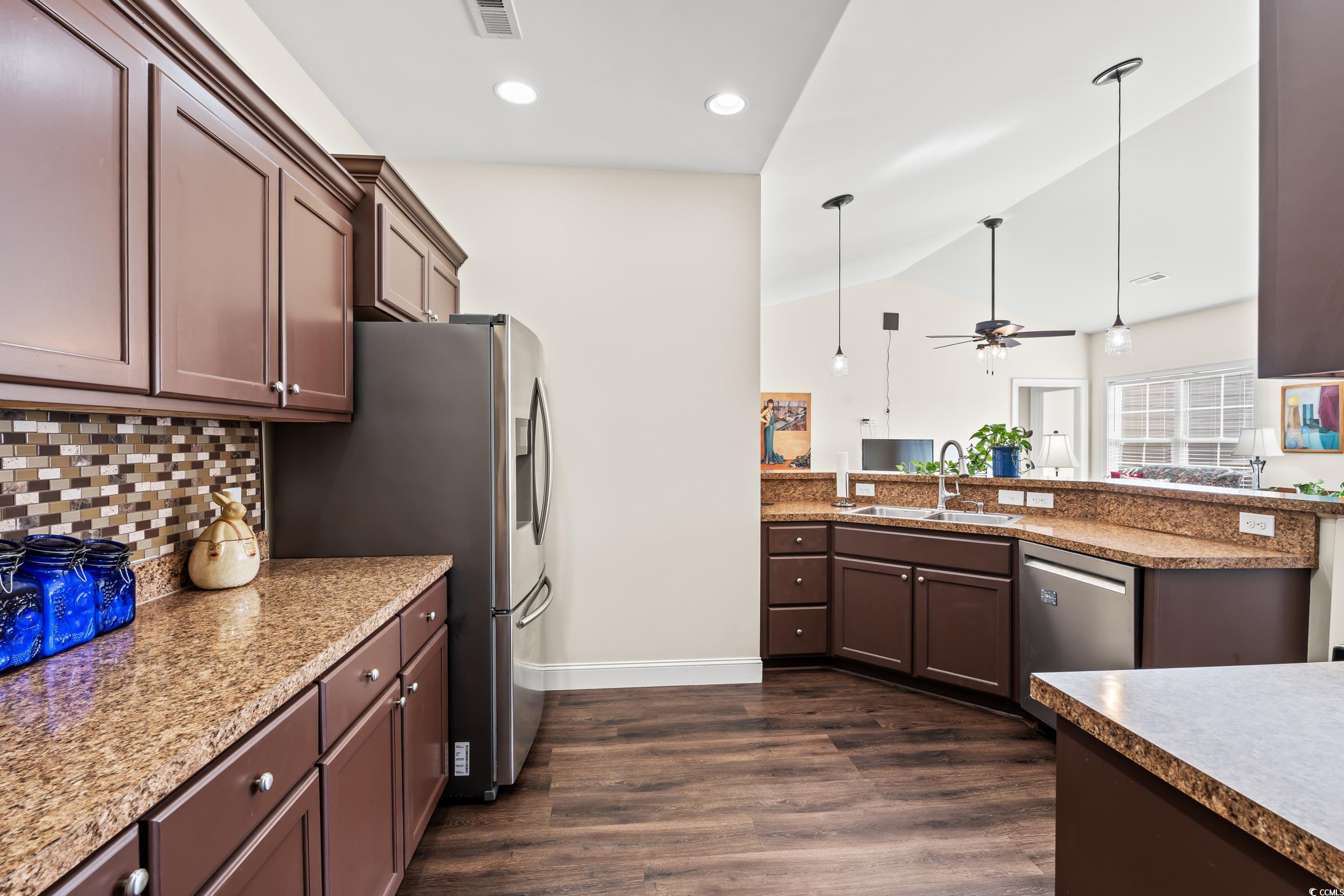 153 Grier Crossing Road Conway, SC 29526 - Photo 7 of 26 Kitchen with hanging light fixtures, vaulted ceiling, dark brown cabinets, appliances with stainless steel finishes, and dark wood-style flooring