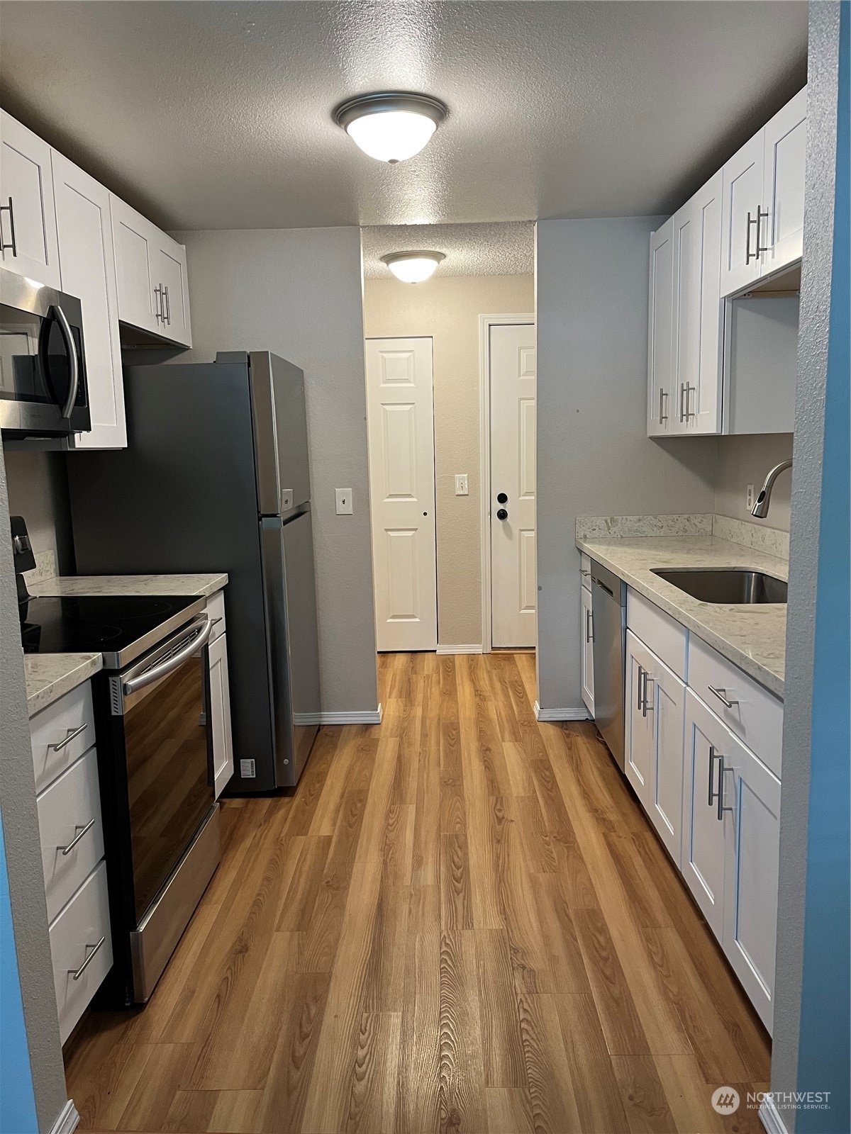 1800 Southwest 318th Place, Unit D Federal Way, WA 98023 - Photo 5 of 22 a kitchen with a sink a refrigerator and cabinets