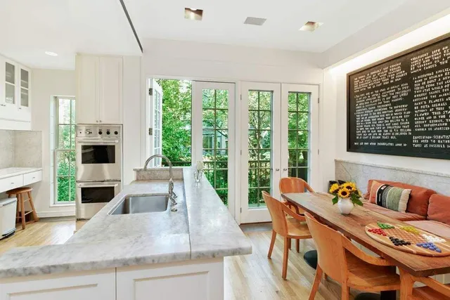 a view of a kitchen with granite countertop a stove a sink a dining table and chairs
