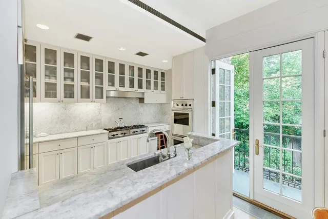 a kitchen with stainless steel appliances granite countertop a sink stove and cabinets
