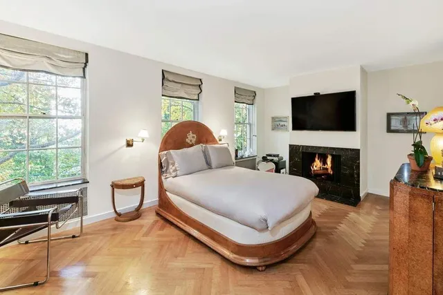 a spacious bedroom with a bed and a flat screen tv