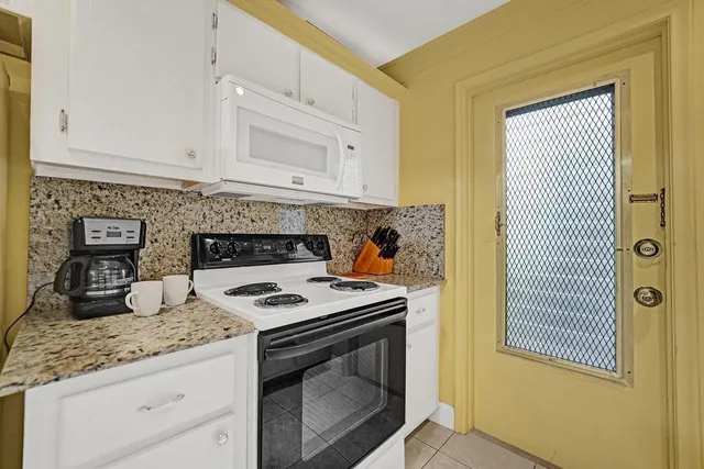 a kitchen with granite countertop white cabinets and sink