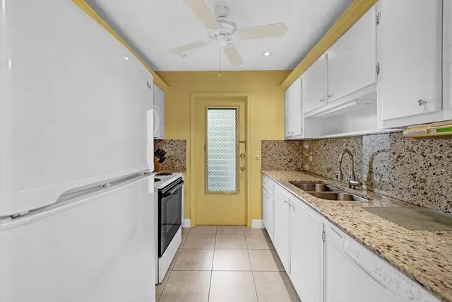 a kitchen with refrigerator a stove a sink and cabinets