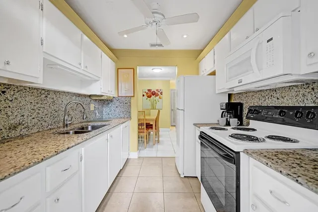 a kitchen with granite countertop stove top oven and cabinets