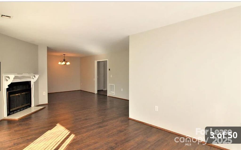4809 Spring Lake Drive, Unit E Charlotte, NC 28212 - Photo 2 of 18 a view of an empty room with a fireplace and wooden floor