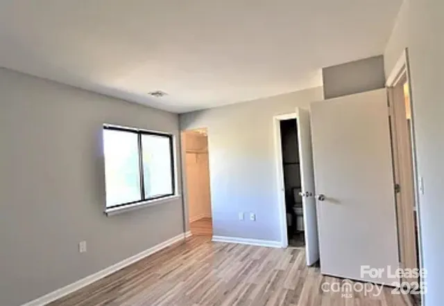 an empty room with windows and closet