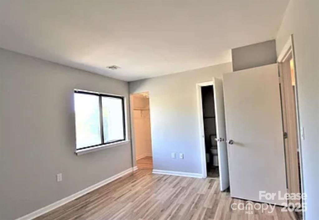 4809 Spring Lake Drive, Unit E Charlotte, NC 28212 - Photo 6 of 18 an empty room with windows and closet