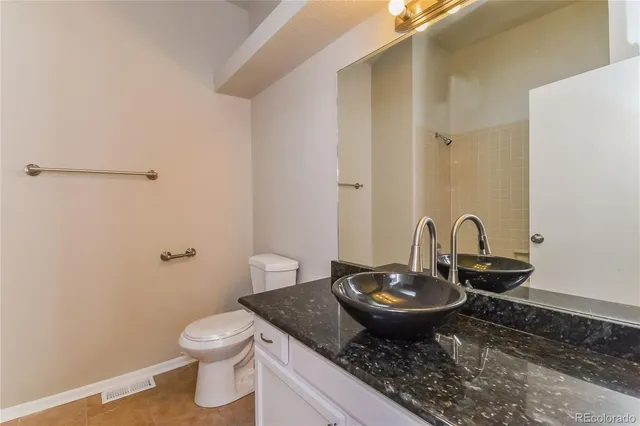 a bathroom with a granite countertop sink and a mirror