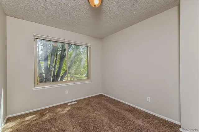 an empty room with windows and air conditioner