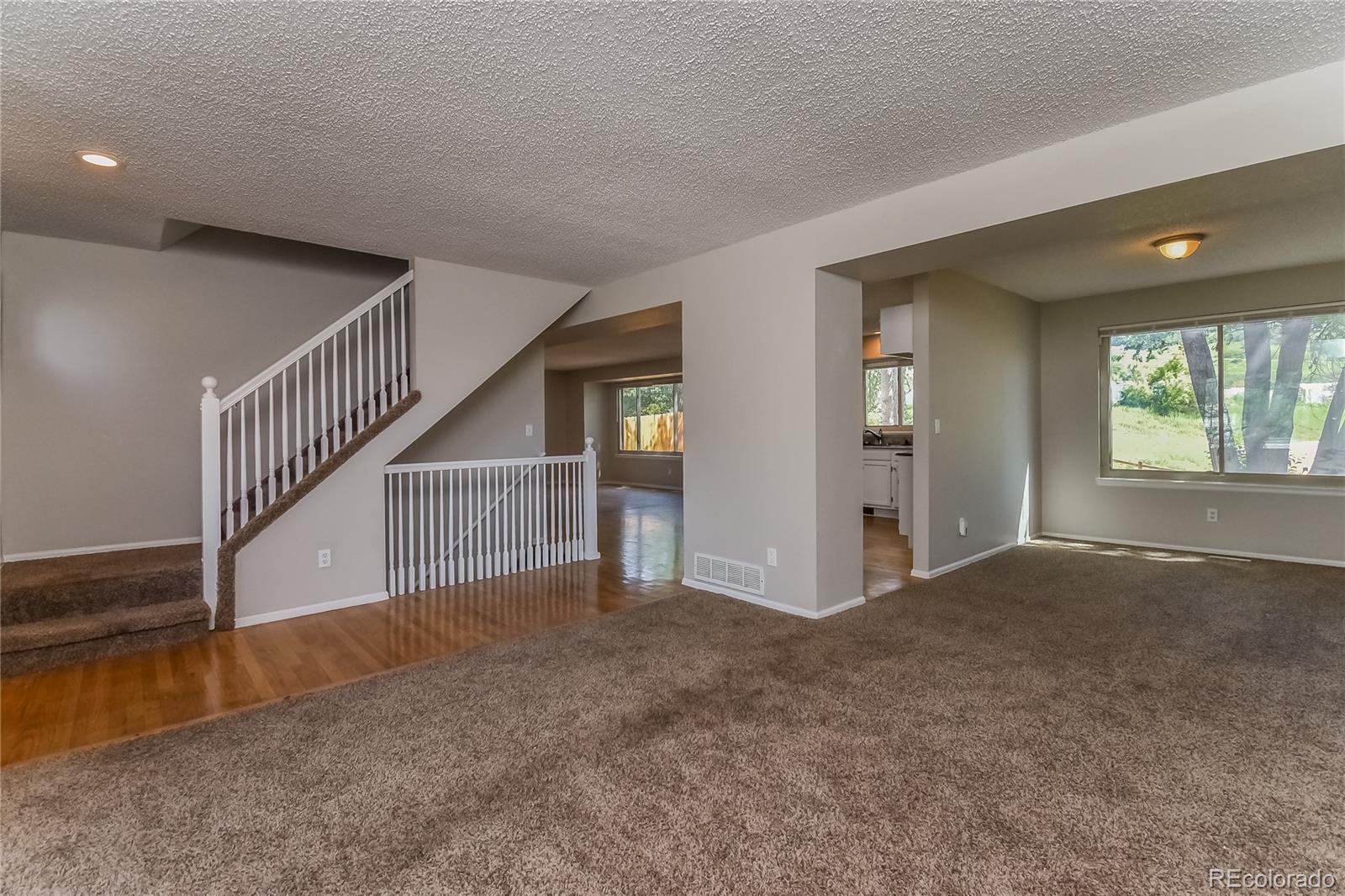 5245 Quasar Court Colorado Springs, CO 80917 - Photo 4 of 18 a view of an empty room with wooden floor and a window