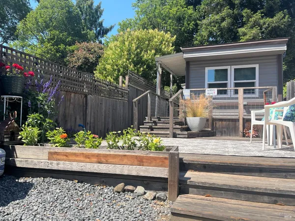 a view of house with outdoor seating and flower garden