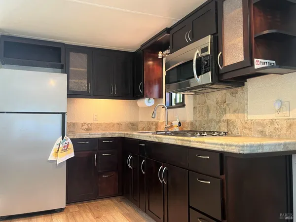 a kitchen with stainless steel appliances granite countertop a sink stove and microwave
