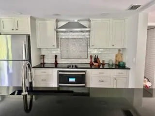 a kitchen with granite countertop cabinets stainless steel appliances and a counter space