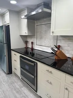 a kitchen with granite countertop white cabinets and stainless steel appliances