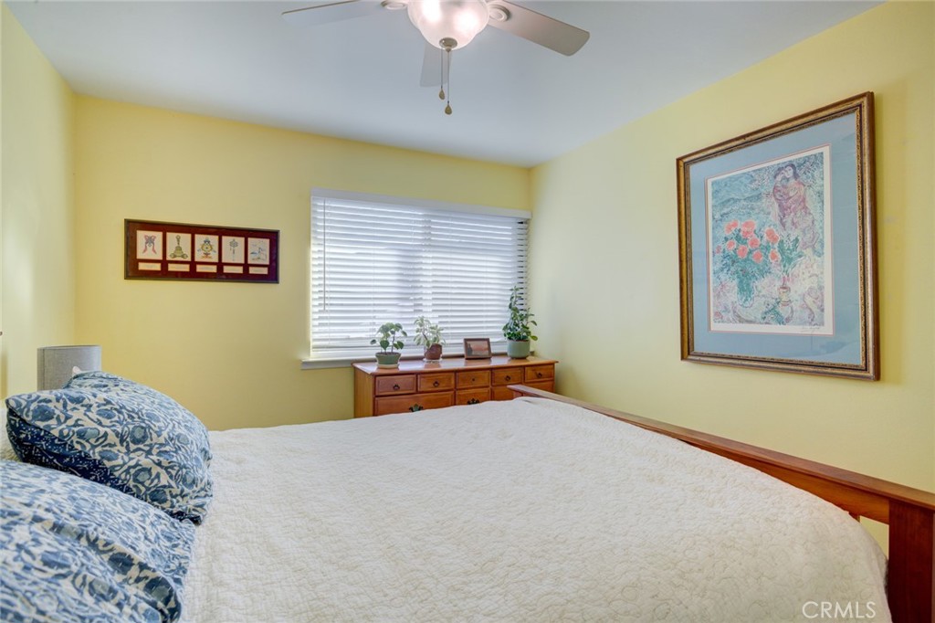 1750 Prefumo Canyon Road, Unit 48 San Luis Obispo, CA 93405 - Photo 17 of 32 a bedroom with a bed and a chandelier