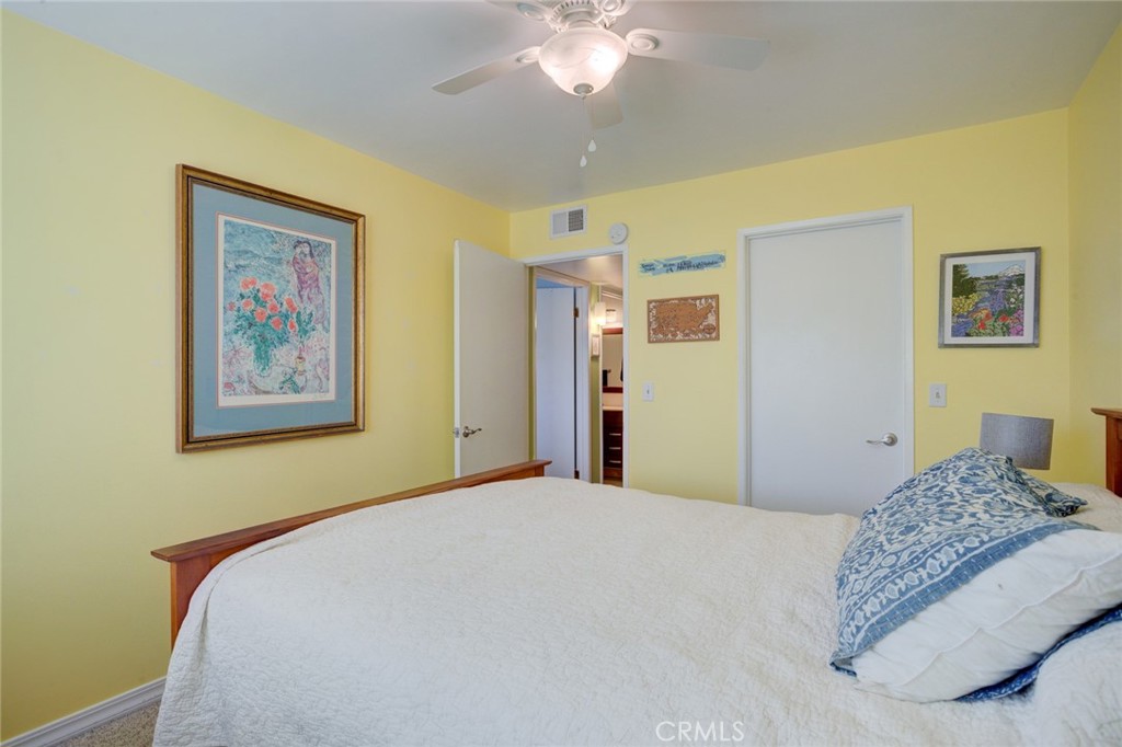 1750 Prefumo Canyon Road, Unit 48 San Luis Obispo, CA 93405 - Photo 18 of 32 a bedroom with a large bed and a chandelier
