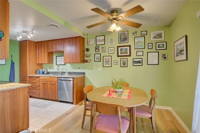 a kitchen with stainless steel appliances granite countertop a dining table chairs and a refrigerator