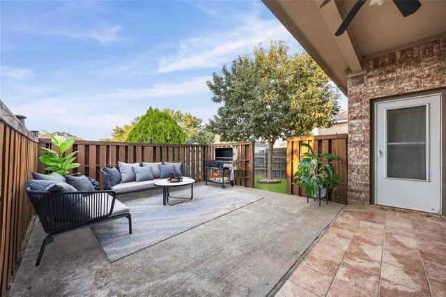 a view of a patio with a table and chairs and potted plants