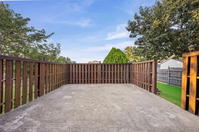a view of backyard with wooden fence and trees