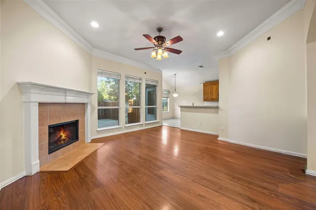 a view of an empty room with window and wooden floor