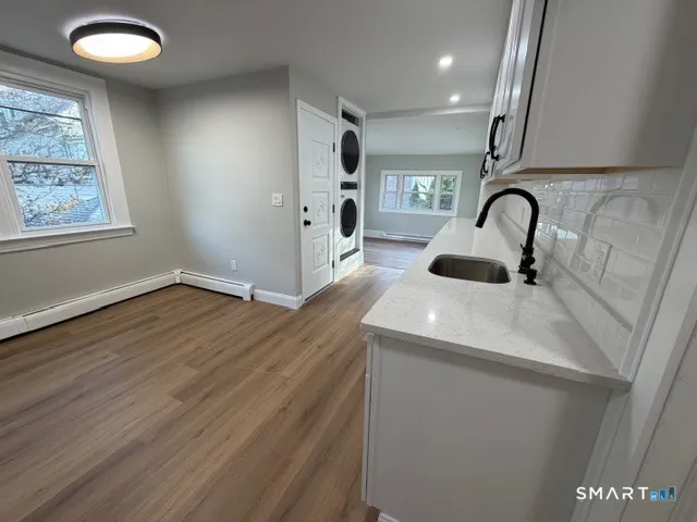 a view of kitchen sink with wooden floor and window
