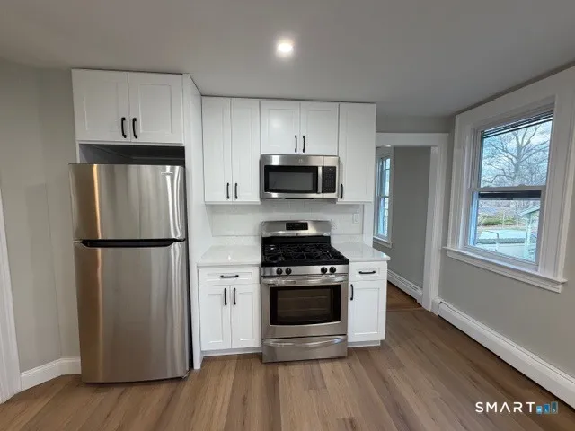 a kitchen with a stove a refrigerator and a microwave
