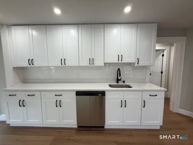 a kitchen with stainless steel appliances granite countertop a sink stove and cabinets