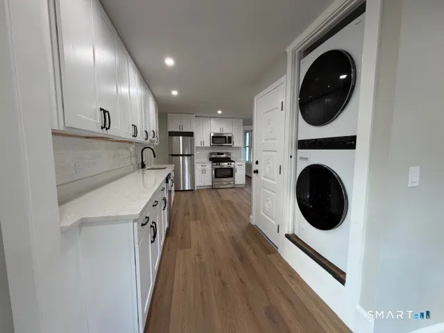 a view of a kitchen with a sink and a washer dryer