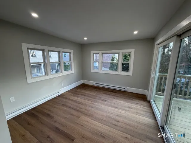 an empty room with wooden floor and windows