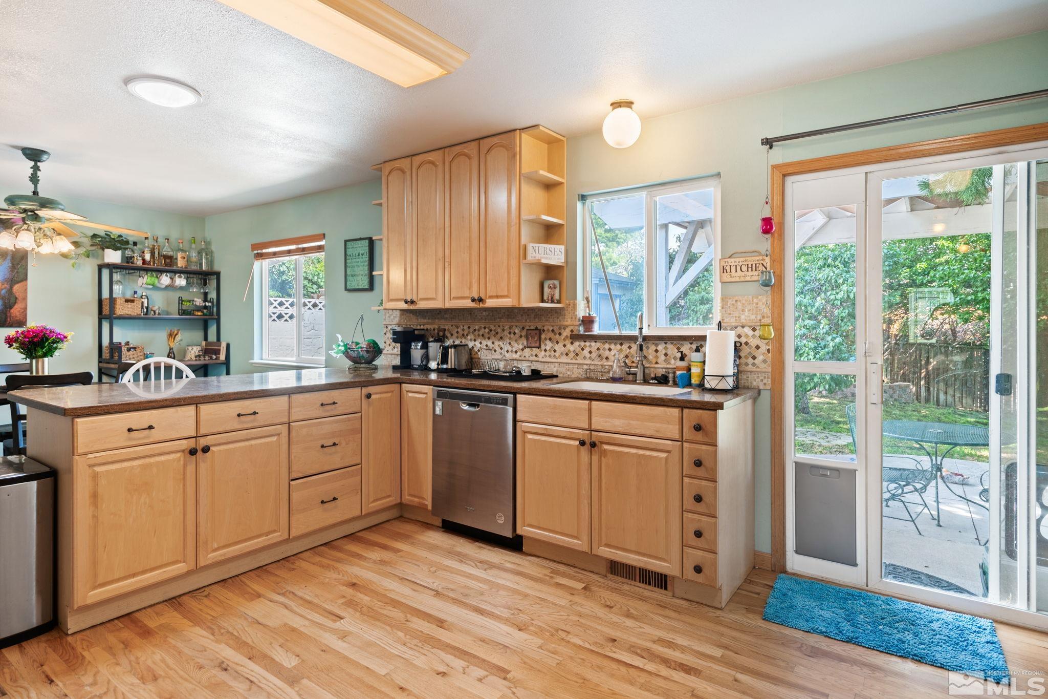 2785 Judith Lane Reno, NV 89503 - Photo 5 of 26 a kitchen with stainless steel appliances granite countertop a stove a sink dishwasher and wooden cabinets with wooden floor