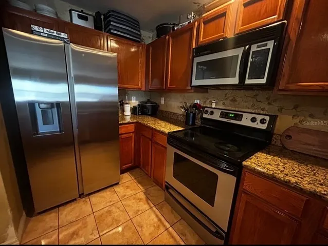 a kitchen with stainless steel appliances granite countertop a stove microwave and refrigerator