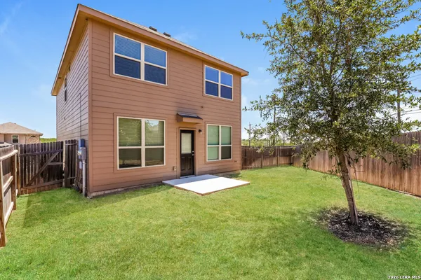 a backyard of a house with a garden and barbeque oven