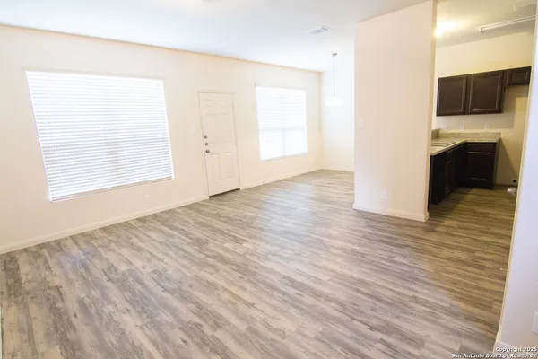 a view of a livingroom with wooden floor and a ceiling fan
