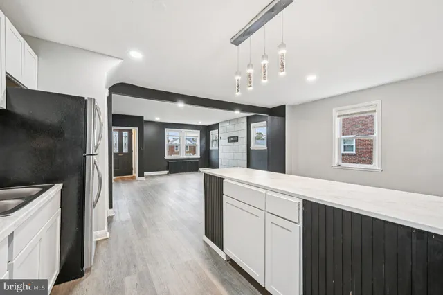 a large white kitchen with a large window