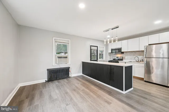 a kitchen with refrigerator cabinets and wooden floor