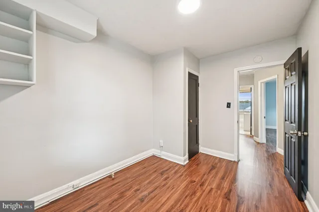a view of a hallway with wooden floor and closet