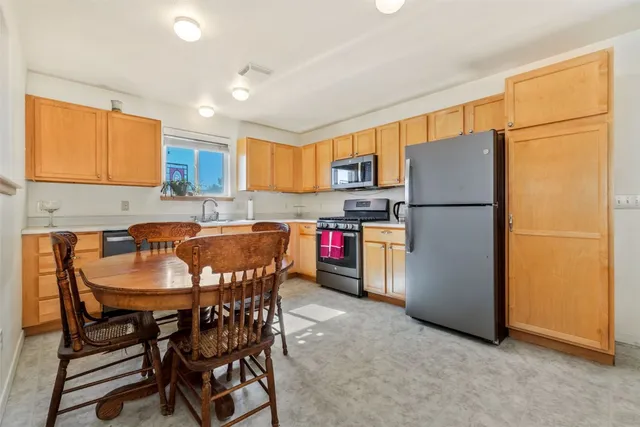 a kitchen with a refrigerator a table and chairs