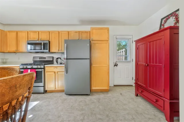 a kitchen with a refrigerator a stove top oven a sink and a window