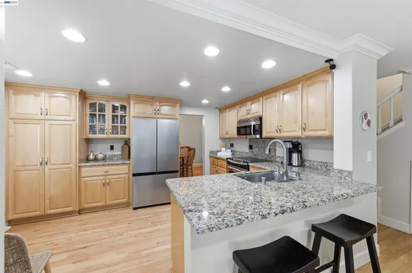a kitchen with stainless steel appliances granite countertop a stove top oven a sink dishwasher and a refrigerator