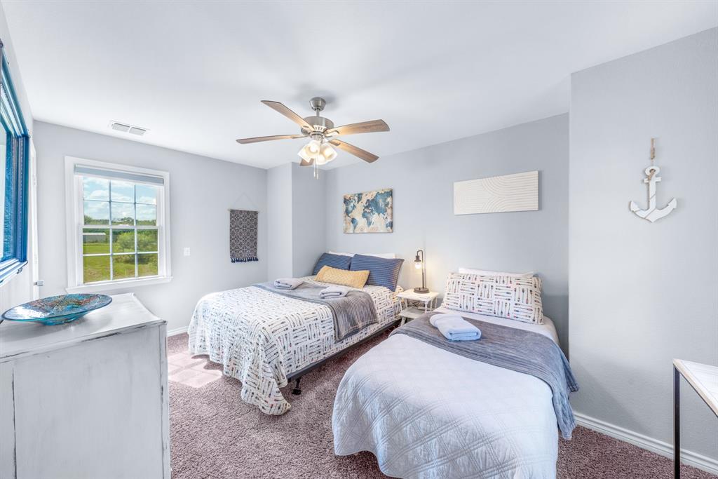 154 Wapiti Quitman, TX 75783 - Photo 18 of 24 a bedroom with two beds and a chandelier