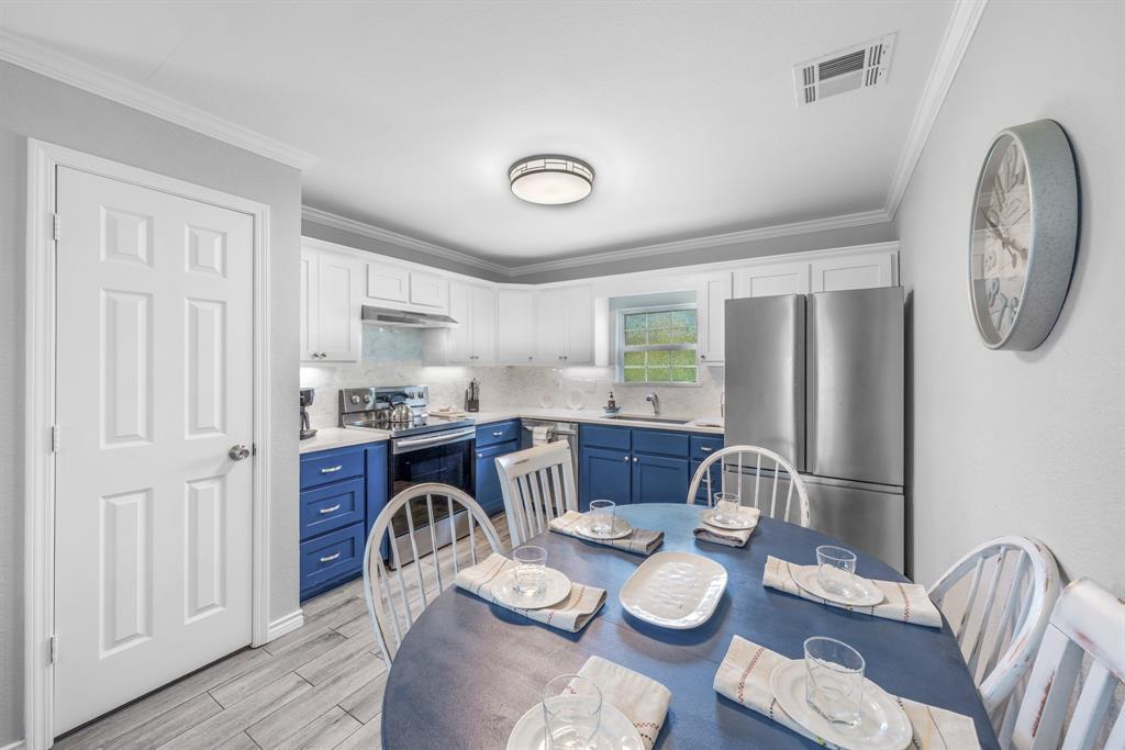 154 Wapiti Quitman, TX 75783 - Photo 8 of 24 a kitchen with stainless steel appliances granite countertop a dining table and chairs with wooden floor