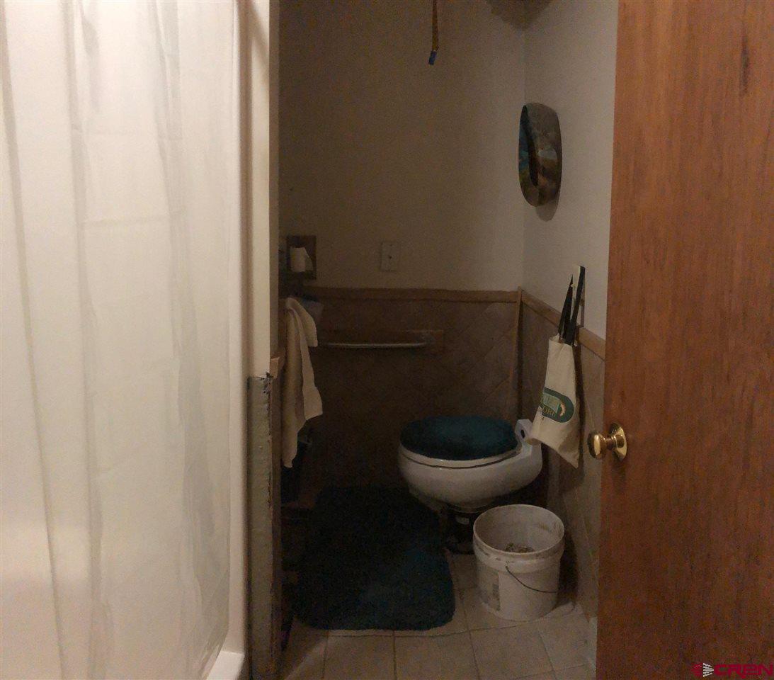 300 Quartz Lane Pitkin, CO 81241 - Photo 10 of 22 a toilet sitting in a bathroom next to a wooden wall
