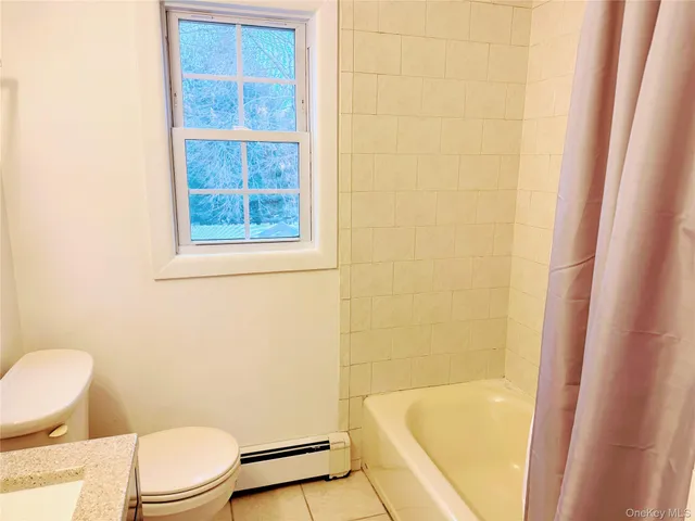 a white toilet sitting next to a bath tub