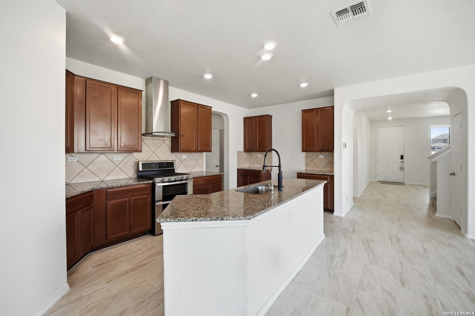 9305 Devils River Converse, TX 78109 - Photo 17 of 34 a large kitchen with granite countertop a large counter top stainless steel appliances and cabinets
