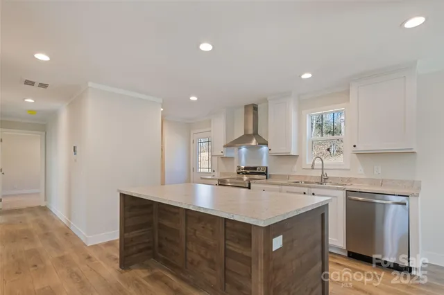 a kitchen with a sink a stove a refrigerator and white cabinets