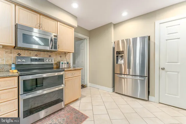 a kitchen with granite countertop a refrigerator and a sink