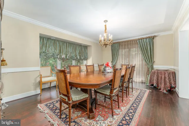 a dining room with furniture a chandelier and wooden floor