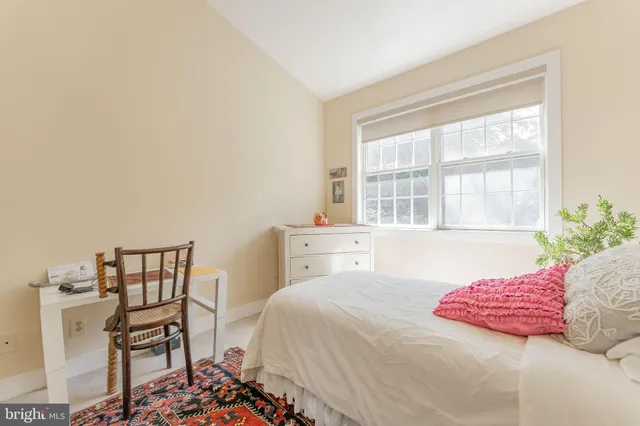 a bedroom with a bed and a large window