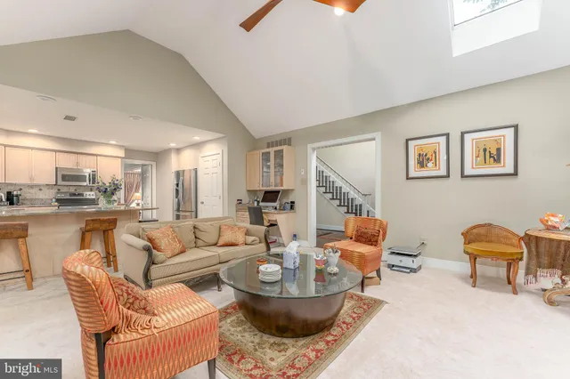a living room with furniture and view of kitchen