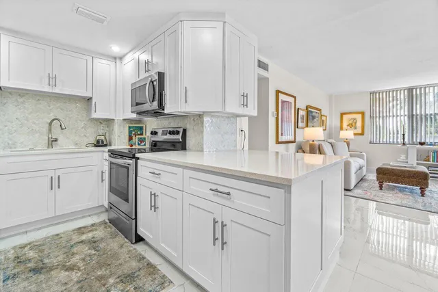 a kitchen with white cabinets and appliances